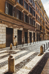 Obraz premium street with ancient buildings and cobbled road on street of Rome, Italy