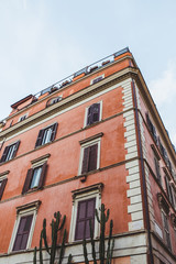 Fototapeta premium bottom view of old building on street of Rome on cloudy day, Italy