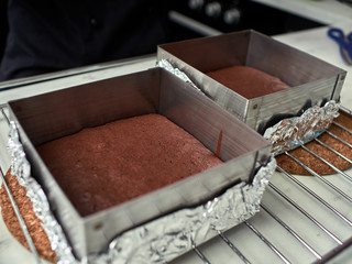 Fototapeta na wymiar Step-by-step preparation of black designer cake. cooked chocolate sponge cake.