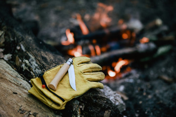 old yellow leather glove and pocketknife in camping - obrazy, fototapety, plakaty