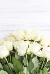 White roses on a white wooden background. Bouquet of white roses