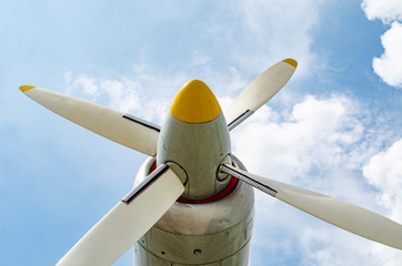 Naklejka na ściany i meble Four blades aircraft propeller on blue sky with white clouds
