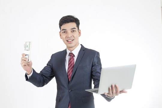 Asian Businessman standing and holding laptop and money on White Background with Success feeling, Business Success Concept, isolated on white background.