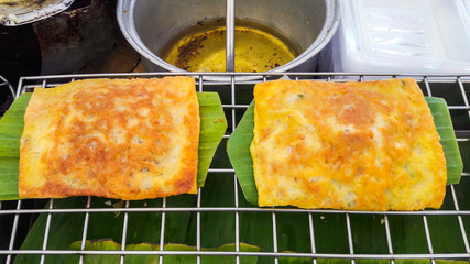 Mix egg and herb  spreaded in pan  to fold ,Thai food style.