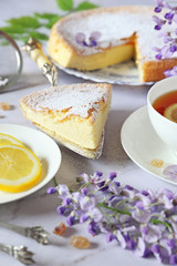 Obraz na płótnie Canvas Spring tea: savoy sponge cake, flowering wisteria and lemon tea