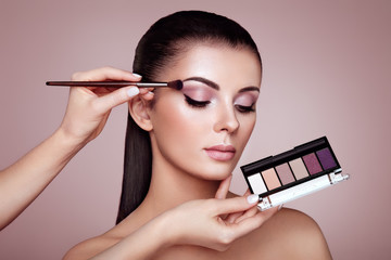 Makeup Artist applies Eye Shadow. Beautiful Woman Face. Perfect Makeup. Make-up detail. Beauty Girl...