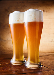 Two tall elegant pint glasses of cold wheat beer