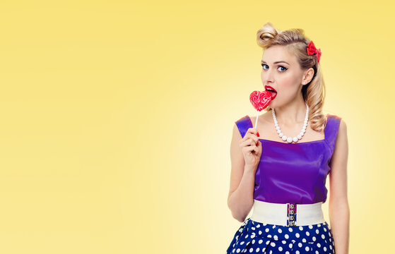 Woman eating lollipop, dressed in pinup style