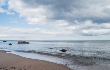 An empty beach with few big stones and calm sea