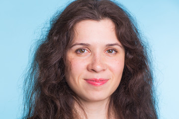 Curly haired woman on a blue background close-up.