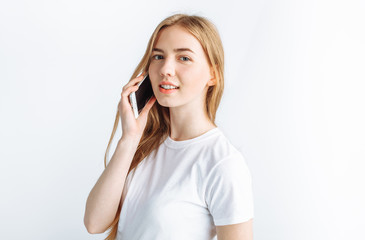 Beautiful young girl talking on the phone, in the Studio, isolated background, cheerful and positive