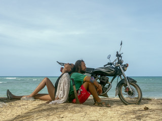 Fototapeta premium A man and a girl are traveling by motorcycle. Beach, sea