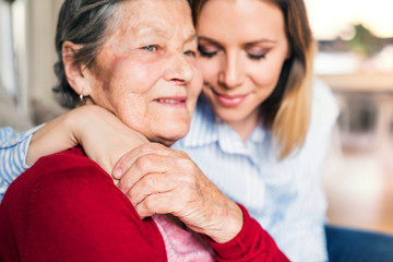 An elderly grandmother with an adult granddaughter at home.