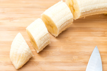 male hands Cutting Banana on the kitchen board. Close-up. Selective Focus.