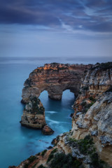 Fototapeta na wymiar Mountains and arches in the shape of a heart on the beach Marinha.