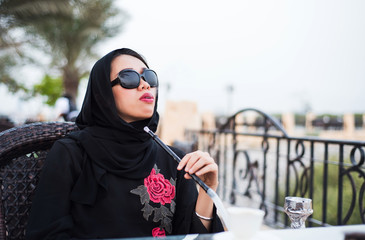 Muslim woman smoking shisha outdoors