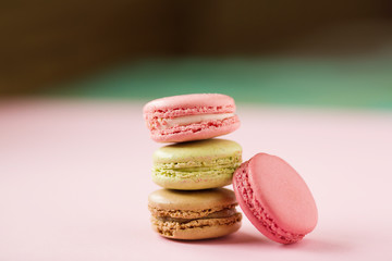 Colored macaroons on a pink  background , colorful almond cookies, pastel colors, vintage card, top view