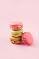 Colored macaroons on a pink  background , colorful almond cookies, pastel colors, vintage card, top view