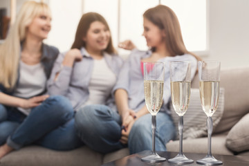 Three young female friends drinking champagne