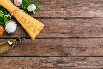 Pasta and ingredients on wooden background with copy space. Top view. Vegetarian food, healthy or cooking concept.