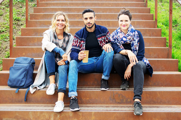Fototapeta premium group of friends sitting outside on stairs