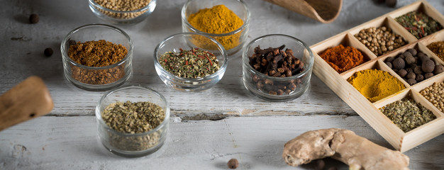 colorful fresh herbs and spices assortment on a white wooden background