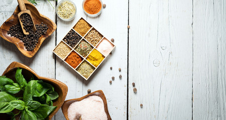 colorful fresh herbs and spices assortment on a white wooden background