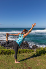 Fototapeta na wymiar Woman Practicing Yoga along the Scenic Maui Coast
