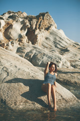 Pretty young woman on the stony seaside beach