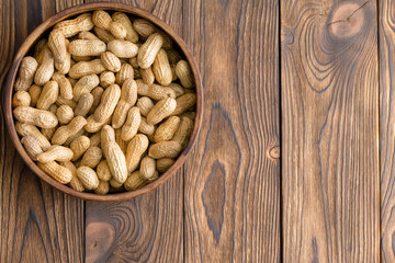 Bowl of whole natural raw peanuts in their shells