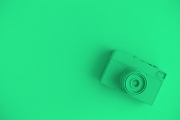 Flat lay of green colored retro camera surrealism abstract concept