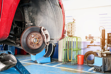 tyre replacement service, Car disc brake without wheels closeup at auto repair garage shop