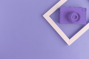 Flat lay of purple vintage camera and photo frame background