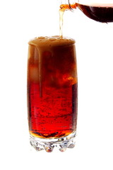 pouring cola into a glass with ice cubes, isolated on white background