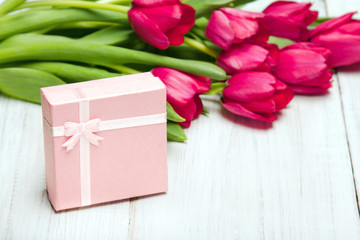 Tulip bouquet and small gift box on white wooden background, copy space