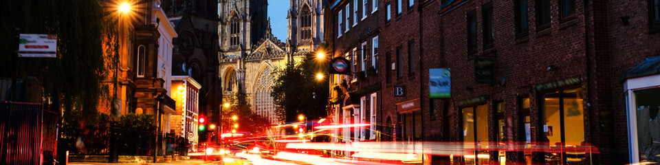Sundown of central York, UK, with York Minster cathedral on the back. Car traffic trail lights in...