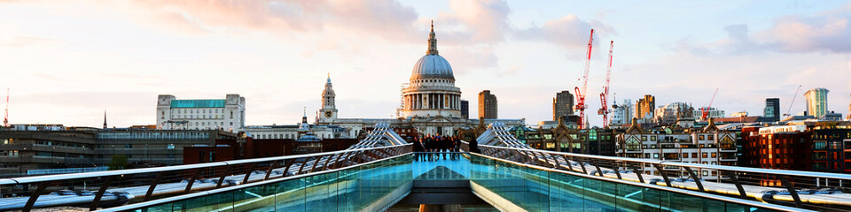 Millennium bridge with Saint Paul Cathedral in the evening in London, UK. Bridge over river Thames