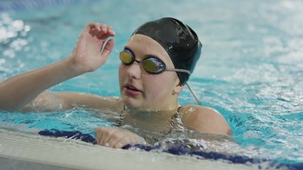 Close up of girl removing goggles and swimming cap in swimming pool / Provo, Utah, United States