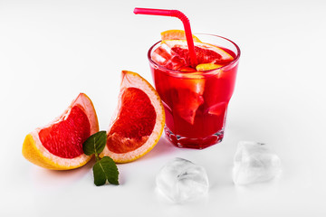 Blood orange gin and tonic cocktail served with slices of orange and ice in a glass on white background