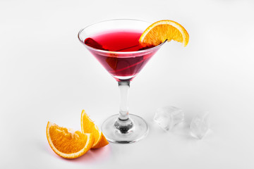 Blood orange gin and tonic cocktail served with slices of orange in a glass on white background