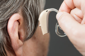Fototapeta premium Closeup senior woman using hearing aid