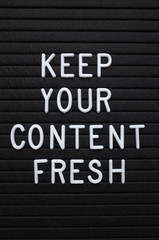 The phrase Keep Your Content Fresh in white plastic letters on a letter board as a reminder to update your marketing and social media platforms