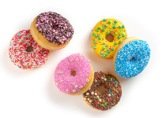 six colorful donuts with frosting, chocolate and sprinkles