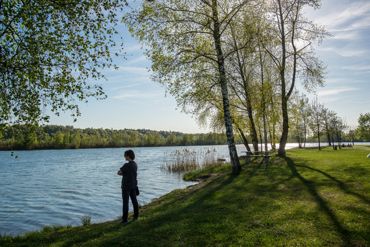 A woman enjoys the scenery by a lake in Bavaria