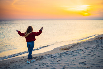 Fototapeta premium Blonde girl on background of the sea comes to a close