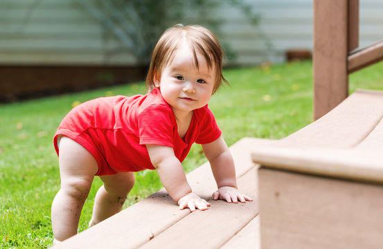 Happy Baby Boy Climbing The Backyard Stairs