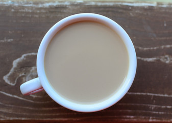 Cup of coffee with milk on a wooden table