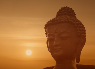 close up of figurine of Buddha against sunset