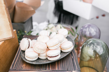 Pastel pink strawberry macarons. French delicate dessert for Breakfast in the morning light on a wooden table. Shallow depth of field. Wedding reception