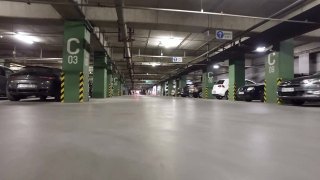 Car driving pov in a busy parking garage in a city mall  low angle view